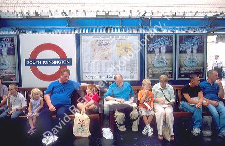 People waiting on station platform of London, England underground station at South Kensington.