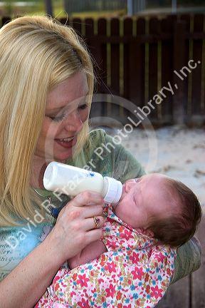 Mother feeding her newborn baby girl a bottle. MR