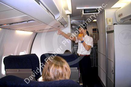 Flight attendent showing how to use an oxygen mask during the preflight safety intsructions.