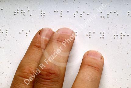 Fingers reading braille.