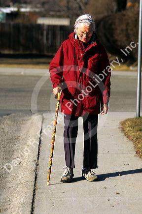 Elderly woman walking with a cane. MR