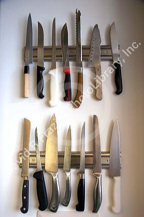 Kitchen knives displayed on magnetic strips.