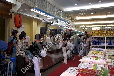 Customers at a supermarket checkout in the Liberdade asian section of Sao Paulo, Brazil.