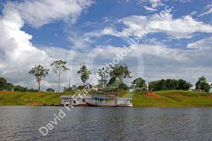 A river boat and house on the Arasa River in the Amazon jungle near Manaus, Brazil.
