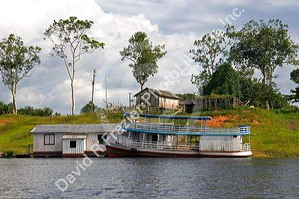 River boat and house on the Arasa River in the Amazon jungle near Manaus, Brazil.