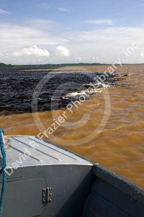 The bow of a boat at the confluence of the Amazon River and the Rio Negro at Manaus, Brazil.