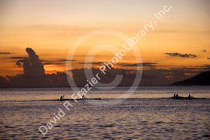 Outrigger canoeing at sunset off the island of Tahiti.