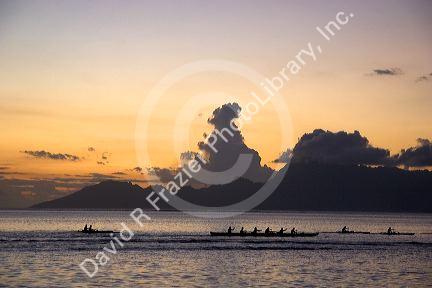 Outrigger canoeing at sunset off the island of Tahiti.