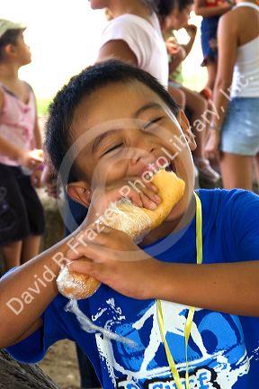 Tahitian boy eating a sandwich on the island of Moorea.