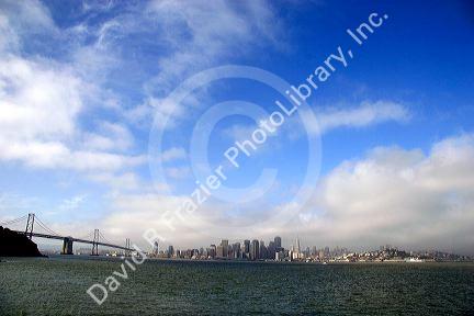 The Bay Bridge and San Francisco, California on a foggy morning.