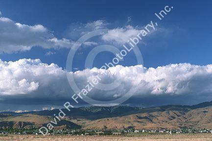Rain storm clouds over Boise, Idaho foothills.  Clouds gather moisture at left and drop rain at right.