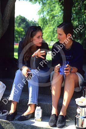 Female german students talking and having lunch in a park.