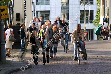 People walk and bike on the streets in Amsterdam, Netherlands.