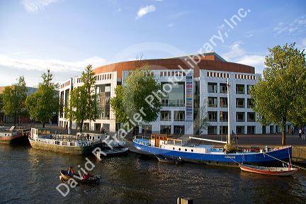 Boating on the Amstel River in front of the Stopera in Amsterdam, Netherlands.