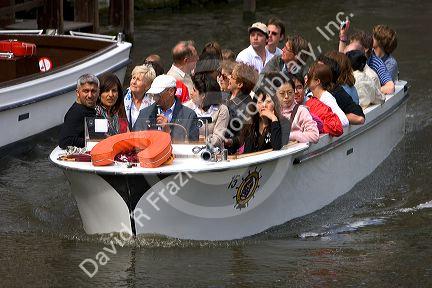 Tourists ride in a canal boat at the city of Bruges in the province of West Flanders, Belgium.
