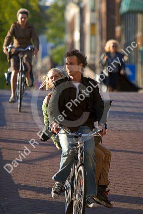 People ride bicycles on the street in Amsterdam, Netherlands.
