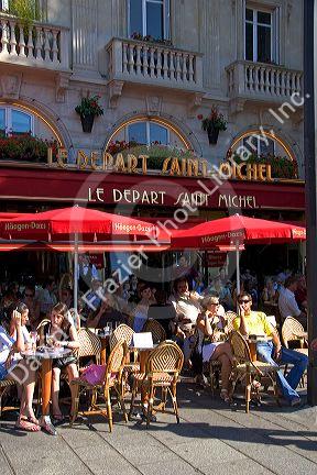 People dine outdoors at the Cafe Le Depart Saint-Michel, open 24 hours in Paris, France.