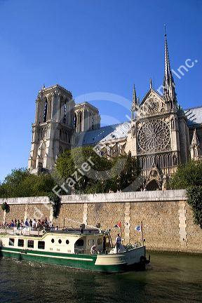 Boat tour on the river Seine passes the Notre Dame cathedral in Paris, France.