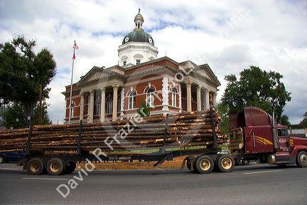 A logging truck passes in front of the historic Meriwether County Courthouse in Greenville, Georgia.