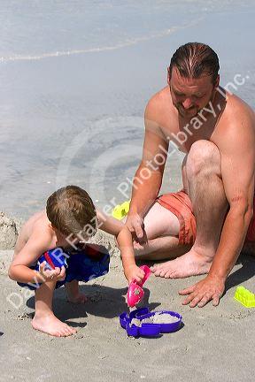 Father and son playing in the sand at the beach in St. Petersburg, Florida. MR