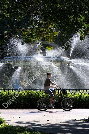 Bicyclist rides past a large fountain in Forsyth Park in the historic district of Savannah, Georgia.
