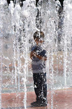 A child stands in the Fountain of Rings in Centennial Park, Atlanta, Georgia.