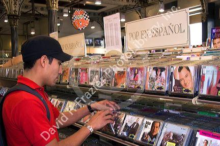A young mexican man shopping for Spanish language cd's at a music store in Mexico City, Mexico.