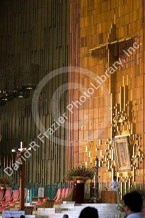 The original tilma of Juan Diego that shows the icon of Our Lady of Guadalupe hangs behind a priest inside the Basilica of Guadalupe in Mexico City, Mexico.