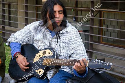 Mexican man playing the acoustic guitar in Mexico City, Mexico.