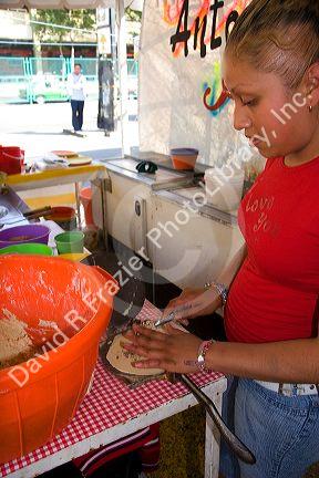Mexican woman making corn tortillas in Mexico City, Mexico.