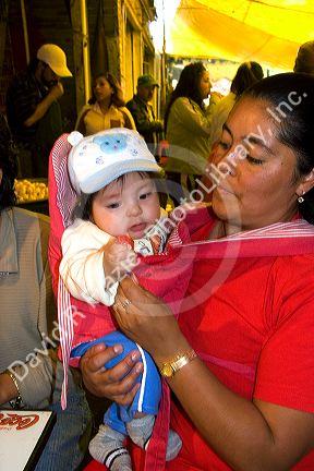 Mexican woman and her infant child at the Merced Market in Mexico City, Mexico.