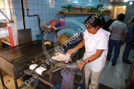 Mexican woman making corn tortillas at the Merced Market in Mexico City, Mexico.