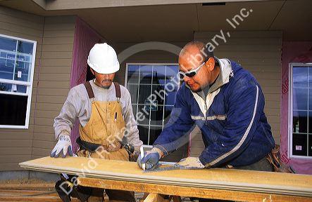 Apprentice at left taking direction from a Journeyman on a construction site.
