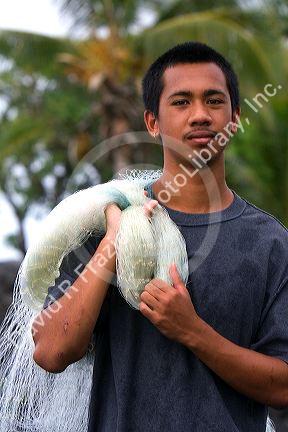 Hawaiian young man holding a fishing net on the Big Island of Hawaii.
