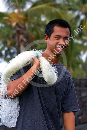 Hawaiian young man holding a fishing net on the Big Island of Hawaii.
