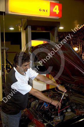 Man filling car with compressed natural gas in Buenos Aires, Argentina.