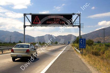 Spanish language road sign reads, Drive With Caution, near Santiago, Chile.