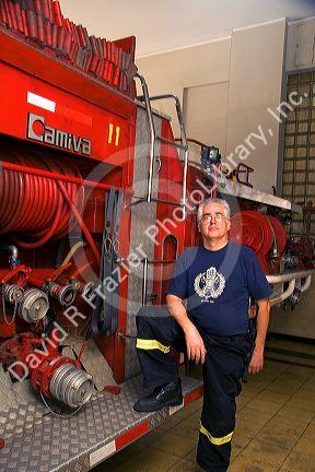 Chilean firefighter standing next to a fire truck at Valparaiso, Chile.
