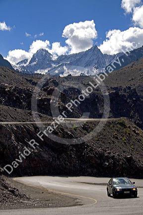 A car drives on switchback roads through the Andes Mountain Range in Chile.