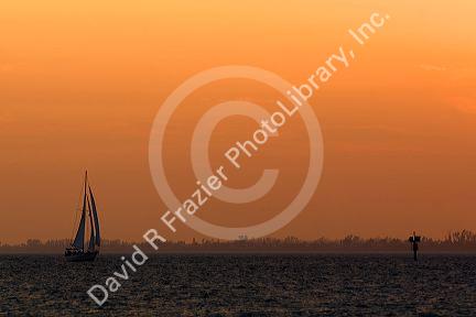 Sailboat and sunset at Fort Myers Beach on Estero Island in Lee County, Florida.