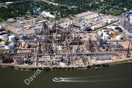 Aerial view of a tugboat traveling on the Houston Ship Channel past an oil refinery in Houston, Texas.
