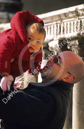Italian father holding up his young daughter at Verona, Italy.