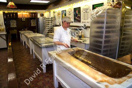 Worker making chocolate fudge at a candy shop in Sault Ste. Marie, Michigan.