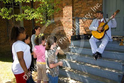 Children watch a musician play the guitar in Greenfield Village at The Henry Ford in Dearborn, Michigan.
