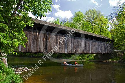 Canoe passing under the Whites Bridge on the Flat River in Keene Township, Michigan.