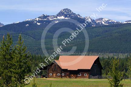 Log barn sits below the Mission Mountains north of Missoula, Montana.