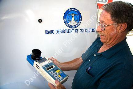 Bureau of Weights and Measures inspector using a device to determine gasoline octane rating in Boise, Idaho.