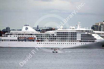 Seaplane taking off in front of the Silversea Silver Shadow cruise ship at Port Vancouver in British Columbia, Canada.