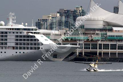Seaplane taking off in front of the Silversea Silver Shadow cruise ship at Port Vancouver in British Columbia, Canada.