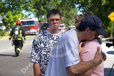 Wife comforting her husband who was a victim of a gasoline explosion causing a house fire in Boise, Idaho.